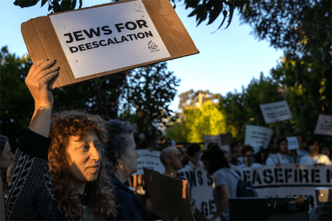 an image of a protestor holding a sign that says "Jews for deescalation"