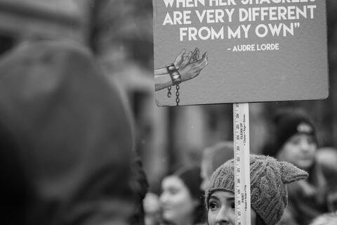 A sign that reads "I am not free while any woman is unfree, even when her shackles are very different from my own" - Audre Lorde
