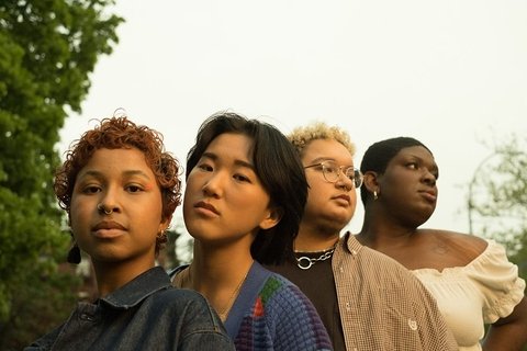 Four friends standing together in a park
