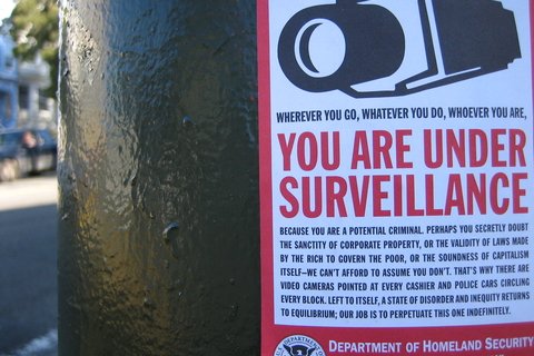 image of electrical pole with DHS surveillance warning poster