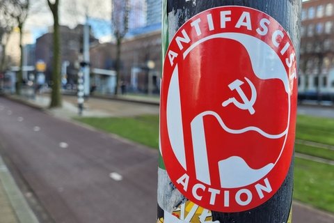 a red sticker on a black pole reads "antifascist action"