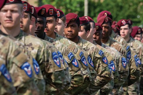 Soldiers in berets stand at attention