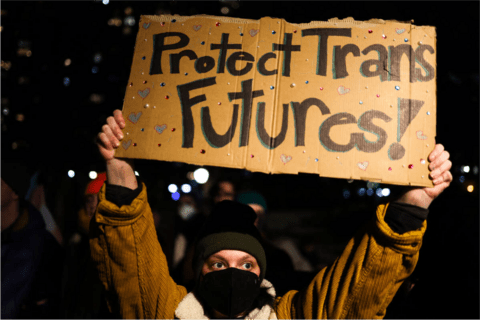 A person holding a sign saying "Protect Trans Futures!"