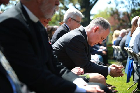 Trump signs an executive order during an event in the Rose Garden to mark the National Day of Prayer at the White House
