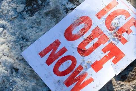 protest sign on icy ground: ice out now