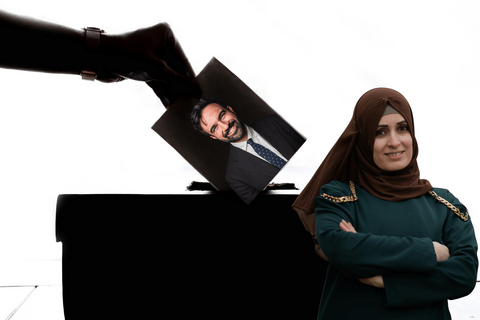 auntie wearing hijab and crossing arms gives side-eye to hand casting ballot for Mamdani