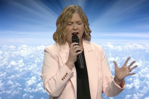 An image of a woman preaching against a cloudy sky