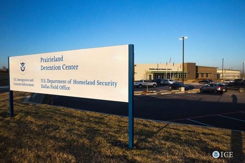 a white sign reads "prairieland detention center" in front of a low brick building