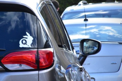 a bumper sticker of the signature QAnon "Q" in a white rabbit.