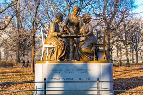 a bronze statue of three women sitting around a table