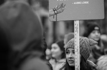 A sign that reads "I am not free while any woman is unfree, even when her shackles are very different from my own" - Audre Lorde