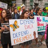 Protesters hold various signs and banners at a DACA rally in San Francisco.