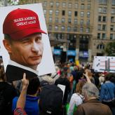Protest sign of Putin wearing MAGA hat