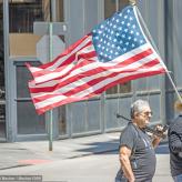 Coronavirus lockdown protestors hold American flag and gun, April 21, 2020 (Credit: Becker1999/flickr)