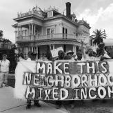 Protesters holding a sign that says "Make this neighborhood mixed income"