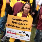 A young girl holding a sign that says Celebrate Teachers - Celebrate Choice! National School Choice Week