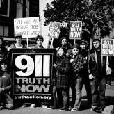 A group photo in BW of protestors holding signs that read 911 Truth Now