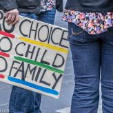 A banner at a protest that says "Pro Choice, Pro Child, Pro Family"