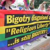 A rainbow flag with the words: Bigotry disguised as "Religious Liberty" is still Bigotry!