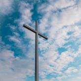a cross with clouds in the background.