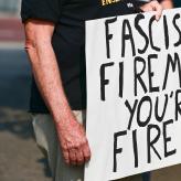 a sign that says "Fascist Fireman: You're Fired!"