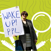 a person holding a sign saying "wake up ppl"