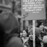A sign that reads "I am not free while any woman is unfree, even when her shackles are very different from my own" - Audre Lorde