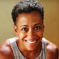 A Black woman with short curly hair in a grey tank top
