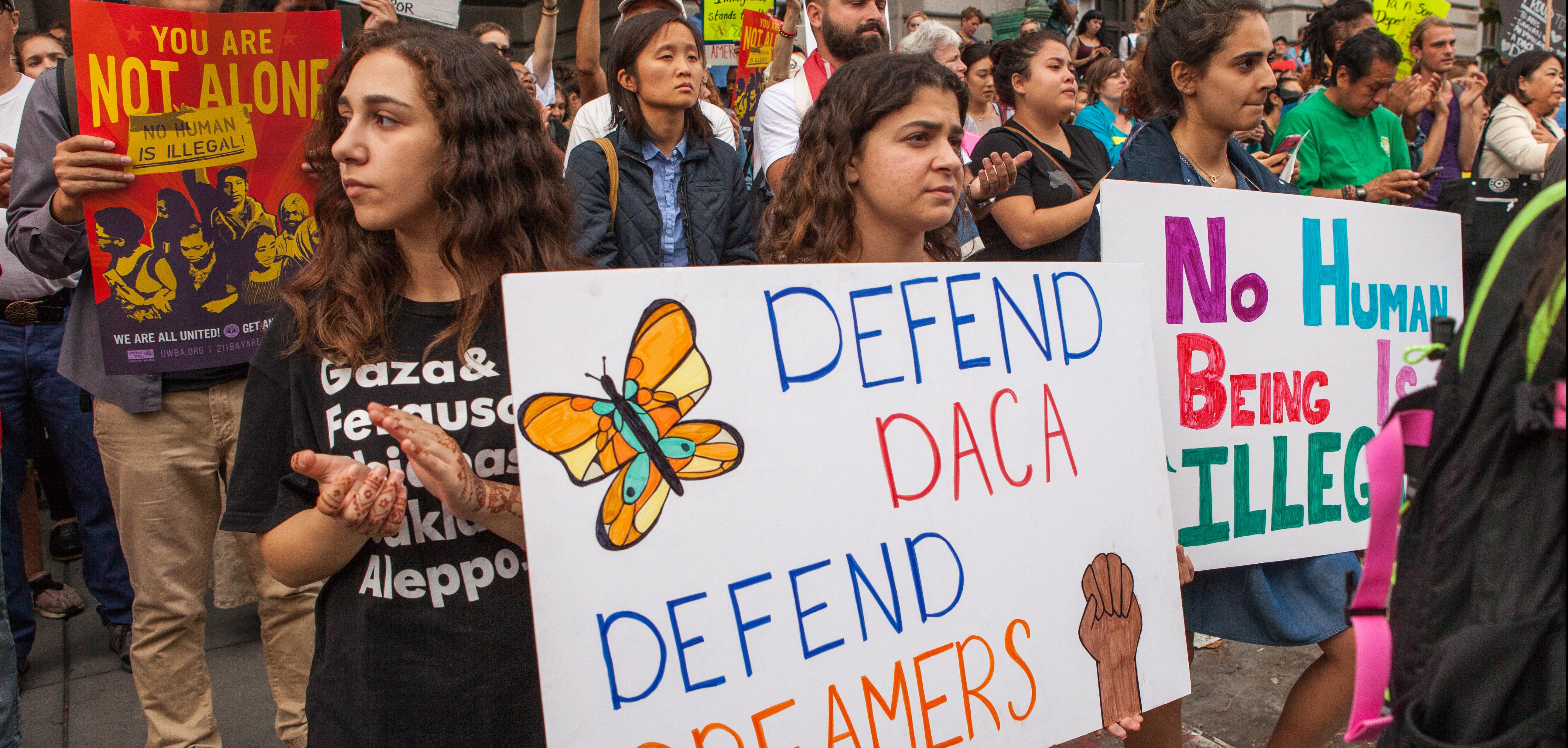 Protesters hold various signs and banners at a DACA rally in San Francisco.