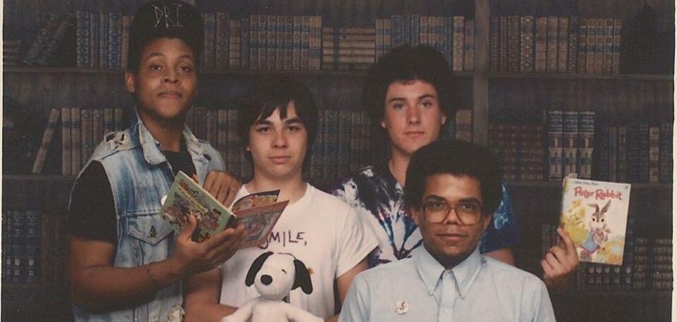 Young Eric Ward posing with friends holding books