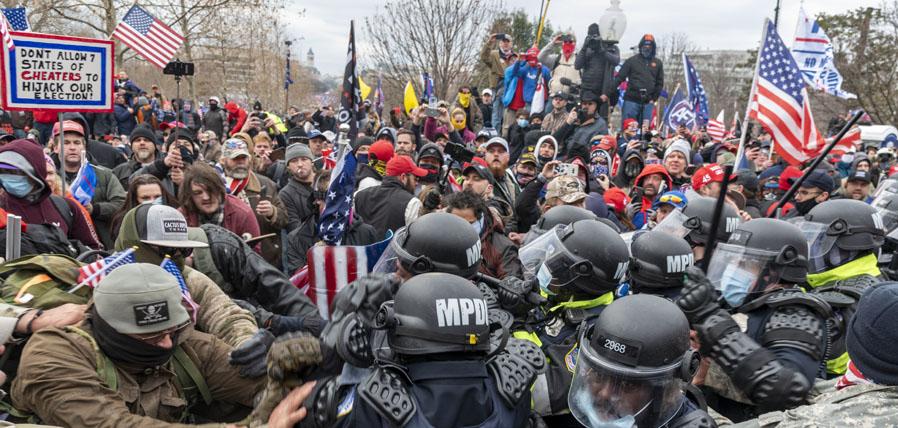 insurrectionists clashing with police on January 6th. Men are pushing against each other.