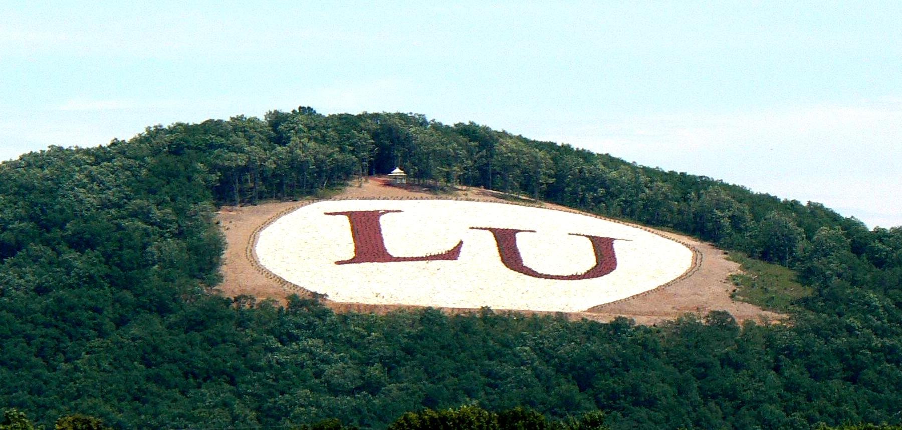 The letters LU in red on a green mountain