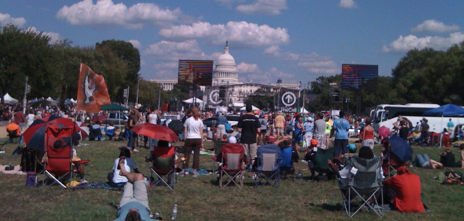 People standing in a field sporadically in front of the D.C capitol