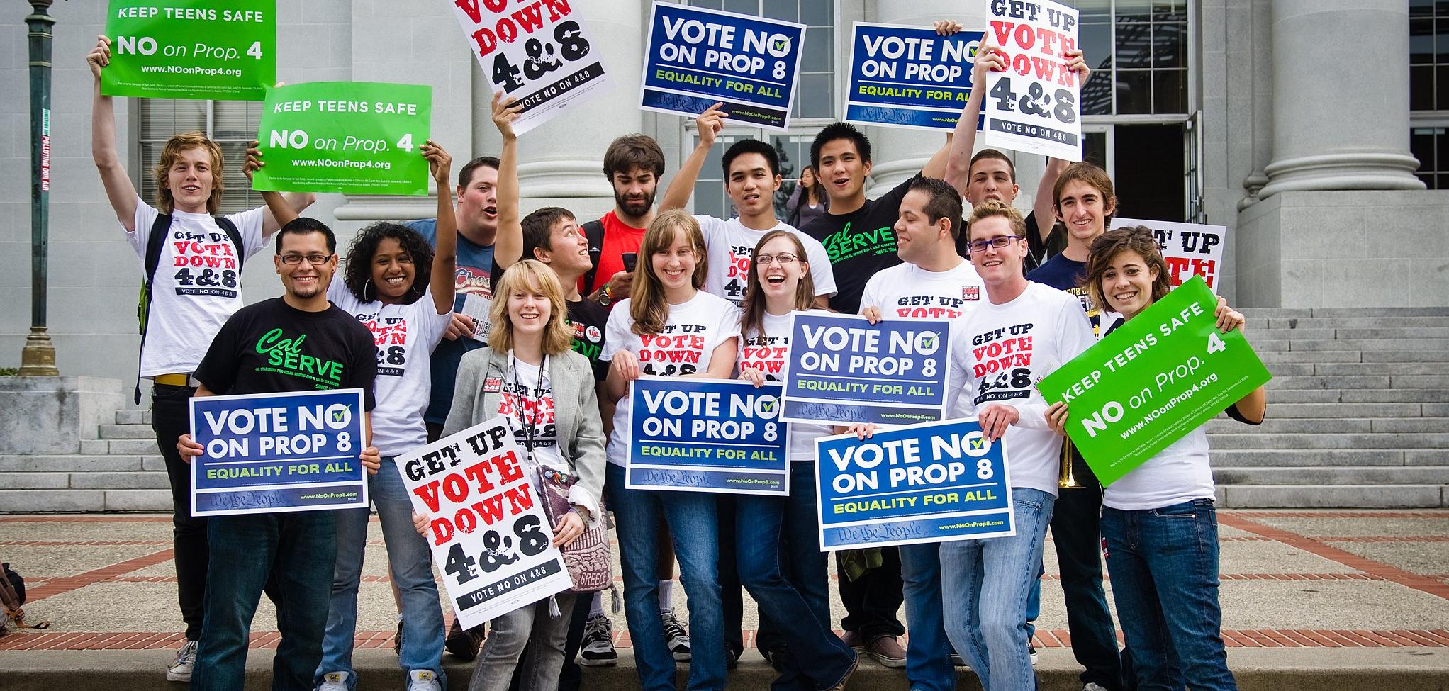 A group of people holding signs that read "Vote No on Prop 8"