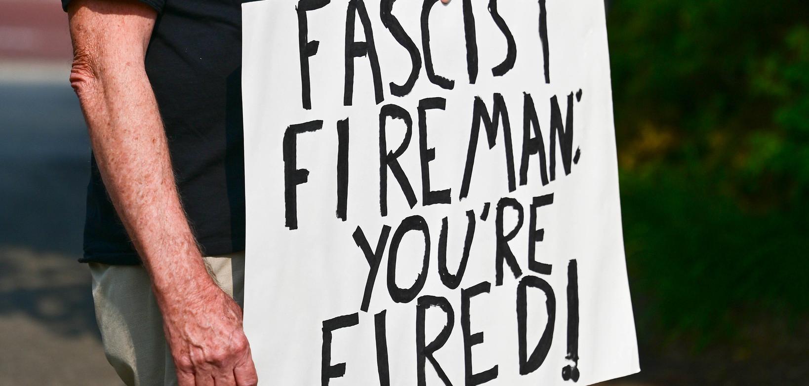 a sign that says "Fascist Fireman: You're Fired!"