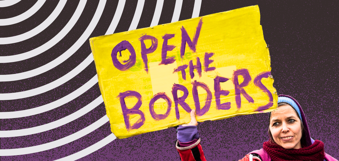 A woman holding a sign that says Open the Borders
