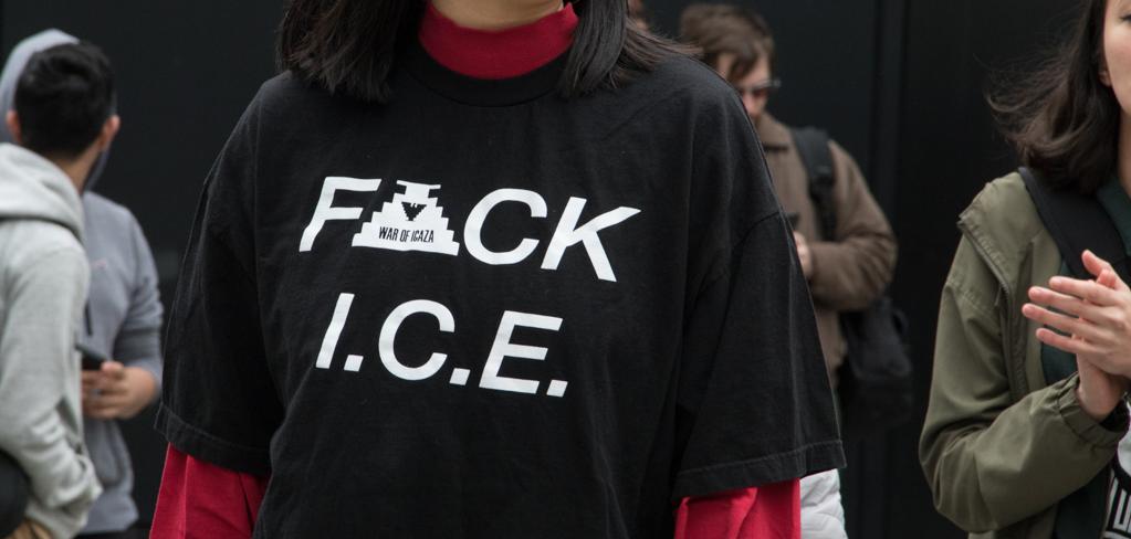 A woman with her eyes closed wearing a black shirt that says "F ck ICE"