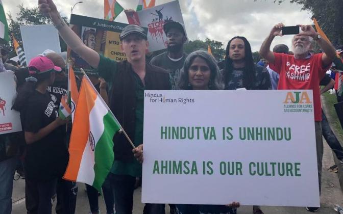 A group of people holding a sign that says "Hidutva is unhindu, Ahimsa is our culture."