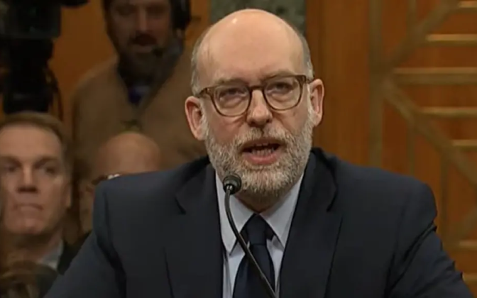 A man in glasses wearing a suit.