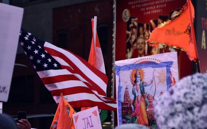American and saffron flags around a framed picture of the deity Ram.