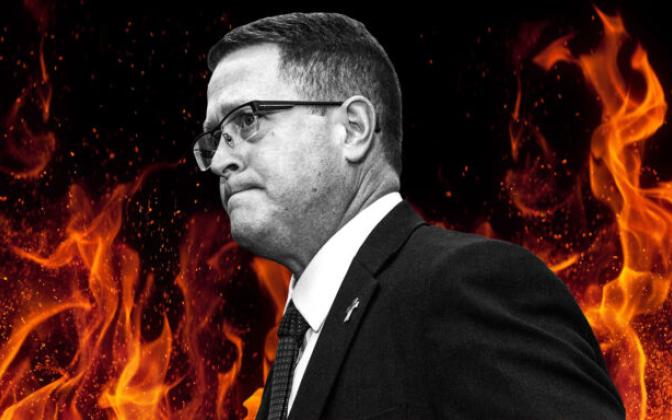 A black and white image of a man with a flames behind him