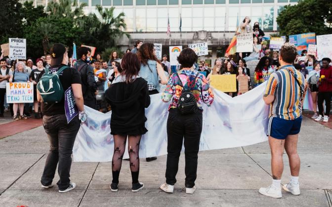the backs of protestors in favor of trans rights